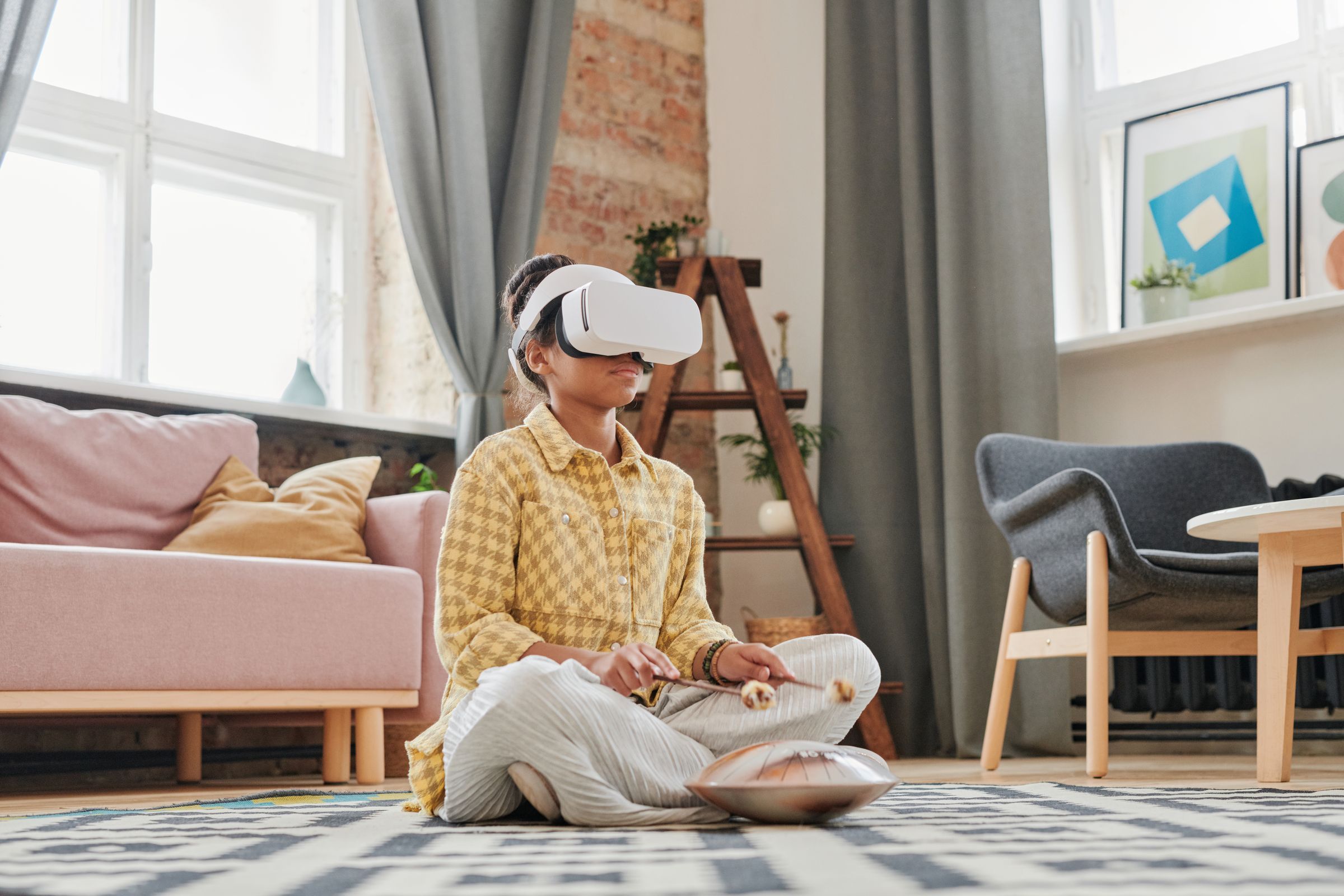 A child sits cross-legged at home wearing a VR headset