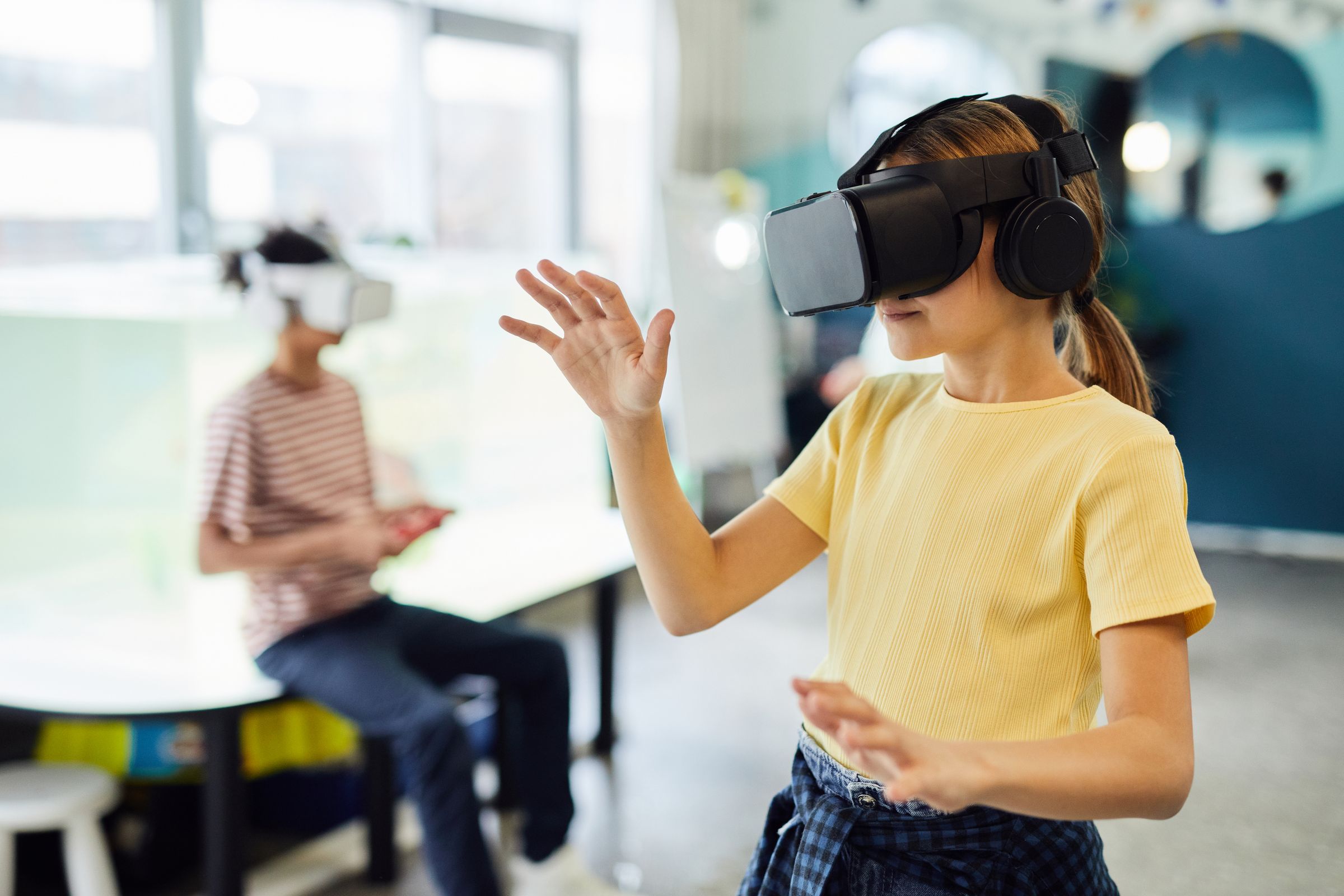A girl reaches out while wearing a VR headset